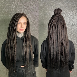 A person with long, dark brown dreadlocks styled in a bun.