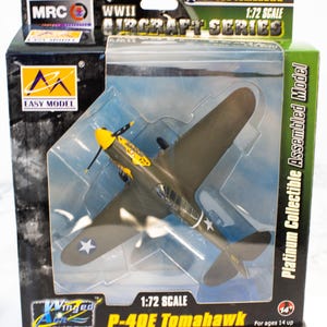 Könnte beinhalten: Ein Modellflugzeug P-40E Tomahawk im Maßstab 1:72, Teil der WWII Aircraft Series. Das olivgrüne Flugzeug hat einen gelben Propeller und Sternzeichen. Das Modell ist in einer Box mit den Logos "Easy Model" und "Winged A" verpackt.