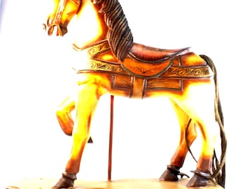 May include: A vintage wooden rocking horse with a brown and tan color scheme. The horse features a detailed mane, saddle, and decorative accents. It is mounted on a wooden base with small metal wheels, suggesting a toy or decorative item.