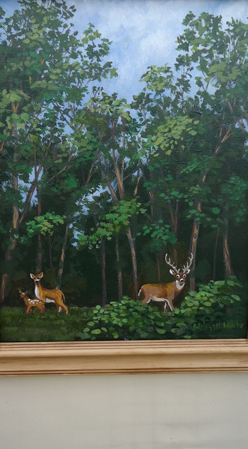 K&ouml;nnte beinhalten: Ein Gem&auml;lde, das eine Waldszene mit drei Rehen zeigt. Die Rehe sind braun und wei&szlig; und stehen auf einer Lichtung im Wald. Die B&auml;ume sind gr&uuml;n und der Himmel ist blau. Das Gem&auml;lde ist in einem hellen Holzrahmen gerahmt.