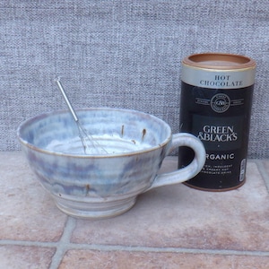 Taza de gres hecha a mano, color marfil crema con esmalte moteado, ideal para sopa, chocolate caliente o café con leche.