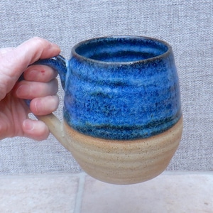 Puede incluir: Un juego de tres tazas de cerámica con un acabado moteado y mate. Las tazas son de color crema, gris claro y gris oscuro. Cada taza tiene un diseño simple y minimalista y un asa redondeada.