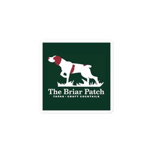 Puede incluir: Una pegatina cuadrada con un fondo verde oscuro. Presenta la silueta de un perro blanco con marcas rojas. El texto "The Briar Patch" está debajo del perro, con "TAPAS • CRAFT COCKTAILS" debajo.