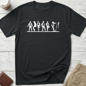 May include: A black short-sleeved t-shirt featuring a white graphic print across the chest. The design displays a series of seven silhouettes of a person wearing a hat and suit, each captured in a different dance pose, all aligned on a horizontal line.