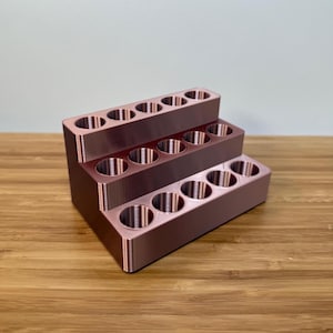 May include: A three-tiered rose gold lipstick organizer with 15 slots for storing lipstick tubes.