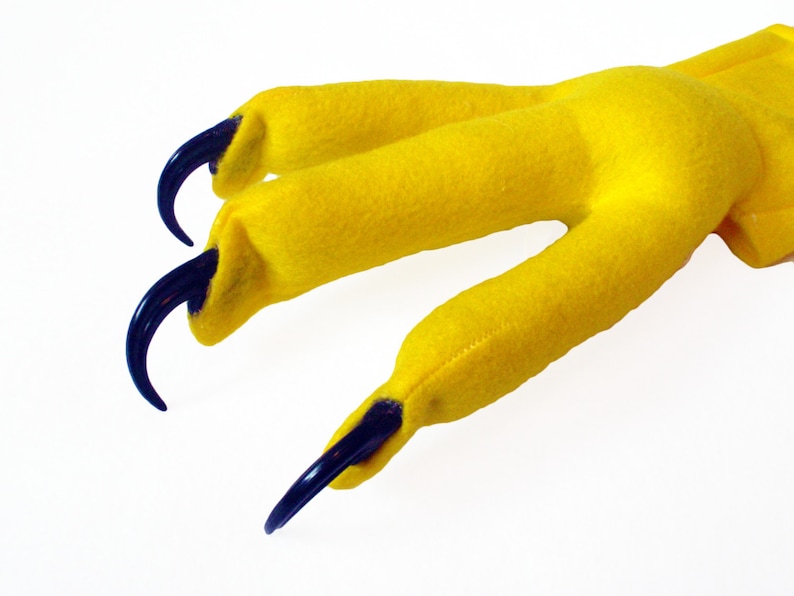 May include: Yellow felt hand puppet with three black claws. The puppet is designed to look like a bird of prey claw.