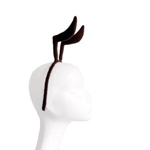 May include: A brown felt headband with two curved antlers attached to the top.