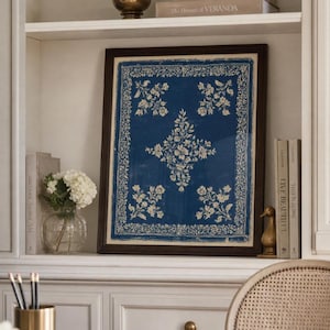 May include: A framed rectangular print featuring a deep blue background with a cream-coloured floral pattern. The design includes a central diamond-shaped floral motif surrounded by four smaller floral clusters and a decorative border.
