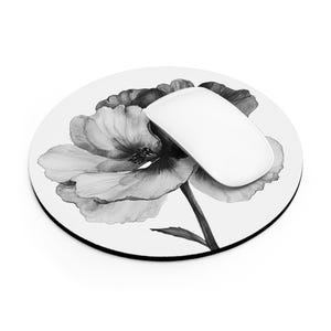 May include: A round black and white mouse pad with a black and white poppy flower design.