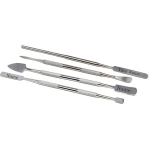 May include: Five stainless steel tools with textured handles and various tip shapes. The tools have the words "Name" and "Your Name" engraved on them. The tools are arranged diagonally against a white background.