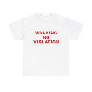 May include: A white short-sleeved t-shirt featuring the text WALKING HR VIOLATION printed in a bold, red, stencil-style font across the center of the chest. The garment has a crew neckline and a standard fit with short sleeves.