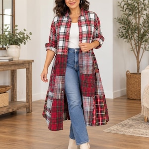 May include: A long-sleeved, button-down shirt dress featuring a patchwork design of red, white, and grey plaid flannel fabric. The garment is worn over a plain white tank top and blue denim jeans, paired with beige ankle boots.