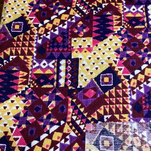 Puede incluir: Una tela vibrante con un patrón geométrico. El diseño presenta un mosaico de formas en tonos de amarillo, morado, burdeos y rosa. Triángulos, cuadrados y rombos crean un textil audaz y colorido.
