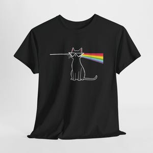 Könnte beinhalten: Ein schwarzes Kurzarm-T-Shirt mit einer weißen Strichgrafik einer sitzenden Katze, die eine dreieckige Brille trägt. Eine weiße horizontale Linie trifft von links auf die Brille und tritt rechts als mehrfarbiger Regenbogen-Prismenstrahl aus.