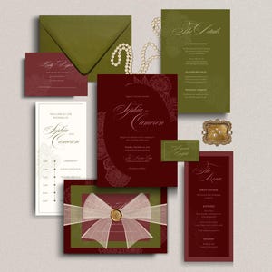 Puede incluir: Un conjunto de papelería de boda con tarjetas en color burdeos intenso y verde oliva con texto en caligrafía blanca. El set incluye un sobre, un menú, una tarjeta de detalles, una tarjeta de respuesta y una invitación central con un lazo.