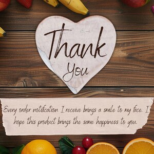 May include: A heart-shaped card with "Thank You" written in elegant script. The card rests on a wooden surface, surrounded by fruit and colored pencils. A message below reads, "Every order notification I receive brings a smile to my face."