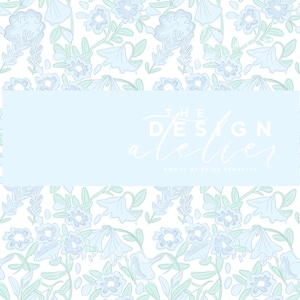 May include: A floral pattern design with light blue flowers and green leaves on a white backdrop. The text "THE DESIGN atelier" is displayed in a light blue rectangle, with "OWNED BY ERIKA KENDRICK" below.