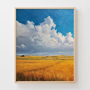 May include: An oil painting in a light wood frame depicts a vast, golden wheat field under a bright blue sky dotted with fluffy white clouds. The landscape features rolling hills and a distant horizon.