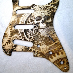 Fender Stratocaster-plektrumskydd, 11 hål, 3-lagers trä, lasergraverad dödskalle med kugghjul, GEARS OF FATE klarlackerad