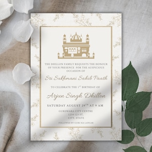 May include: An invitation card with a gold-colored illustration of a building, likely a temple, at the top. The text is in a serif font, with the words "Sri Sukhmani Sahib Paath" and "Arjun Singh Dhillon" highlighted. The card is on a cream background with floral accents.