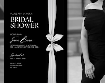May include: Black and white bridal shower invitation with a white satin ribbon and bow. The invitation text reads "Please join us for a Bridal Shower Honoring Sara Bronn Saturday August 18 at 2:00 PM 123-ABC Street. City, Postal Code Registered at Insert Website Here RSVP to Anna at 999-999-9999 by Aug"
