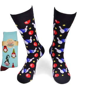 May include: A pair of black socks with a bowling ball and pin pattern. The socks have red, blue, and yellow accents. The socks are shown next to a pair of blue socks with a Christmas gnome pattern.
