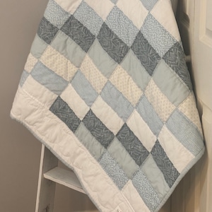 May include: A set of three ceramic mugs with a speckled, matte finish. The mugs are in shades of cream, light gray, and dark gray. Each mug has a simple, minimalist design, perfect for coffee or tea.