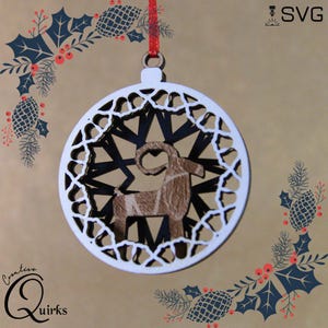 May include: A white, laser-cut wooden Christmas ornament with a goat silhouette inside a starburst design. The ornament is suspended by a red ribbon. The words "Creative Quirks" are in the lower left corner. The word "SVG" is in the upper right corner.