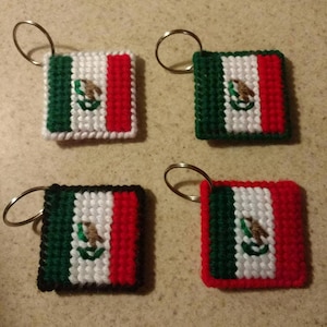 Pode incluir: Quatro chaveiros quadrados com o design da bandeira mexicana. Cada chaveiro tem um esquema de cores verde, branco e vermelho, com o brasão de armas mexicano no centro. Os chaveiros são feitos de um material tecido e têm um anel de metal.