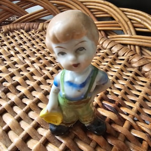 Little boy holding a hat figurine