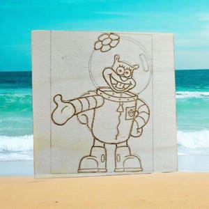 May include: A wood-burned design of a cartoon character wearing a space suit and holding a flower. The character has a large smile and is wearing a helmet with a visor. The design is on a piece of wood.