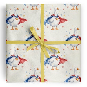 Könnte beinhalten: Geschenkpapier mit einem sich wiederholenden Muster aus weißen Gänsen, die blaue Umhänge mit rotem Futter und gelben Brustemblemen tragen, akzentuiert durch kleine blaue und rosa Sterne, gebunden mit einem gelben Band in Kreuzform.