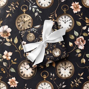 May include: A wrapped gift with a white satin bow sits on a black background patterned with antique pocket watches, flowers, and foliage. The gift wrap features the same pocket watch and floral design. The overall theme is vintage and elegant.