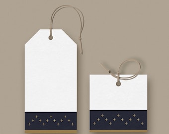 May include: Two white gift tags with a navy blue and gold design. The tags have a string for hanging. The bottom of the tags feature a navy blue band with gold airplane icons. The tags are rectangular and square.