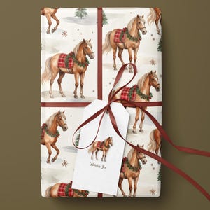 Puede incluir: Papel de regalo con un patr&oacute;n repetitivo de caballos de color marr&oacute;n claro con mantas de cuadros rojos y coronas verdes, atado con una cinta roja oscura y una etiqueta blanca con una ilustraci&oacute;n de un caballo y el texto Holiday Joy.