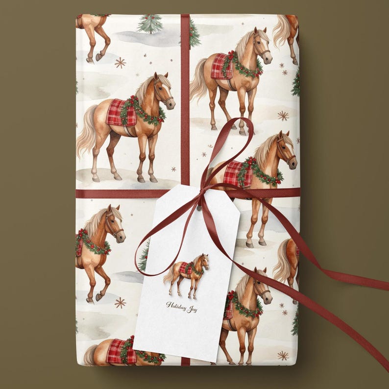 Puede incluir: Papel de regalo con un patr&oacute;n repetitivo de caballos de color marr&oacute;n claro con mantas de cuadros rojos y coronas verdes, atado con una cinta roja oscura y una etiqueta blanca con una ilustraci&oacute;n de un caballo y el texto Holiday Joy.