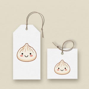 May include: Two white gift tags with a cartoon dumpling illustration. The dumpling has a light brown color with a smiling face. The tags are rectangular and square, with a string attached for hanging.