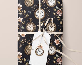 May include: Gift-wrapped package with a black background featuring a repeating pattern of gold-colored pocket watches and floral accents. A white gift tag with a pocket watch design is attached with a cream-colored ribbon.