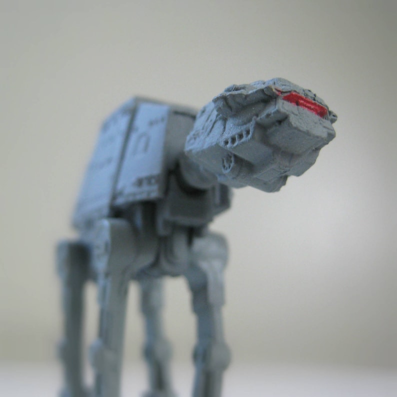 A vintage miniature Star Wars AT-AT Imperial Walker shown close up from underneath the front portion of the ship.
