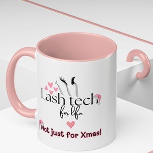 May include: White ceramic mug with a pink interior and handle. The mug features the text "Lash tech for life" with eyelash and heart graphics. Below the text is "Not just for Xmas!"