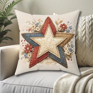 May include: A decorative throw pillow with a star design. The star is composed of red, blue, and tan fabric, with a lace center. Floral accents in red, blue, and white surround the star. The pillow is on a light-colored sofa.