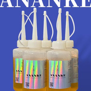 May include: Four clear bottles of ANANKE Nano Polymer Bed Adhesive. The bottles are filled with a clear, slightly yellow liquid. The bottles have a white cap with a long, thin spout. The bottles are labeled with the brand name ANANKE and the product name Nano Polymer Bed Adhesive.