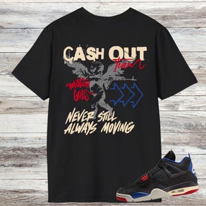 Könnte beinhalten: Schwarzes T-Shirt mit dem Text "CASH OUT Team" und "Motion Gods Never Still Always Moving" in Weiß, Rot und Blau. Das T-Shirt zeigt eine Engel-Grafik. Ein schwarzer, blauer und roter Sneaker befindet sich unten rechts.