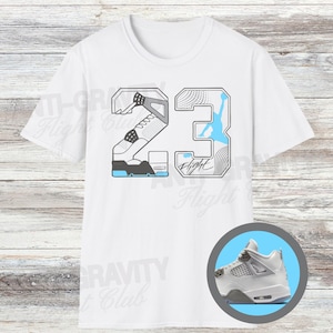 Könnte beinhalten: Weißes T-Shirt mit einem grafischen Design. Das Design beinhaltet die Zahl 23, einen Basketballschuh und eine hellblaue Silhouette eines Basketballspielers. Ein kleineres Bild eines weißen und hellblauen Basketballschuhs befindet sich in einem Kreis.