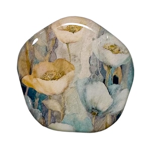 May include: A decorative, irregularly shaped object featuring a floral design. The artwork showcases watercolor-style poppies in shades of cream, yellow, and blue. The surface has a glossy, resin-like finish, giving it a polished appearance.