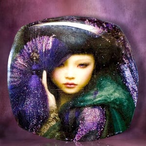 May include: A square-shaped decorative glass plaque featuring a portrait of a person with dark hair, holding a purple glittery fan. The artwork displays deep purple and green tones with a shimmering, reflective finish and rounded corners.