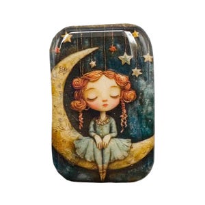 May include: A rectangular, glossy image featuring a whimsical illustration of a girl with red curly hair seated on a crescent moon. The girl wears a blue dress, with stars and a night sky background. Decorative stars hang from above.