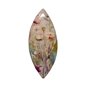 May include: A teardrop-shaped decorative item featuring a floral design with poppies in shades of pink, red, and white. The artwork is set against a muted background of greens and purples, encased in a clear, glossy resin.