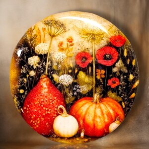 May include: A circular decorative plate featuring a vibrant autumn scene with two orange pumpkins, a small white gourd, and bright red poppy flowers. The background displays a dark, textured field filled with white wildflowers and tall, thin stems.