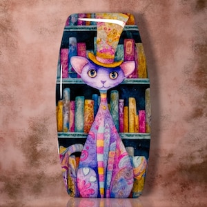 May include: A rectangular wall plaque featuring a vibrant, stylized purple cat wearing a yellow top hat. The cat is positioned in front of a dark bookshelf filled with colorful, textured books. The artwork displays a glossy finish with intricate patterns.
